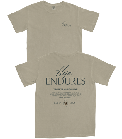 A light beige crewneck t-shirt shown from both the front and back. The front features a small, subtle dark gray script logo on the left chest reading 'Hope ENDURES'.