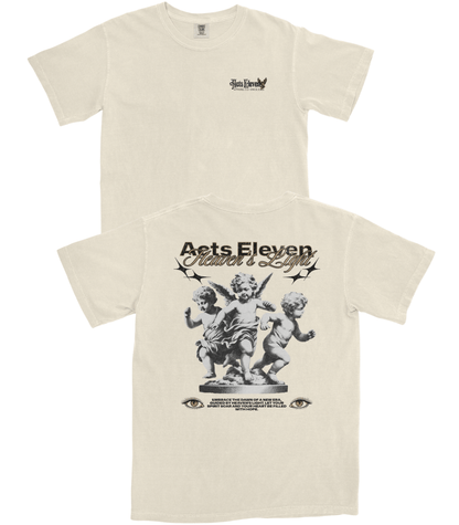 Front and back views of an off-white short-sleeve t-shirt. The front features a small black graphic on the left chest, and the back features a large black graphic of cherubs with the text 'Acts Eleven' and 'Father's Day'.
