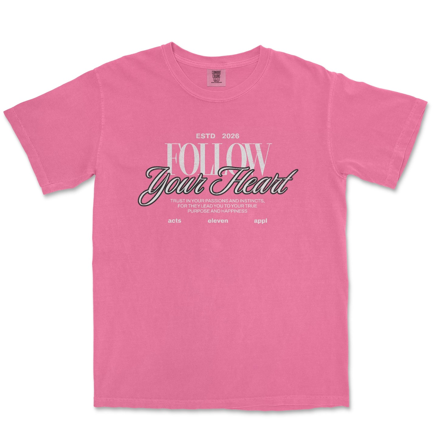 A pink short-sleeve t-shirt with a graphic text print on the front reading 'FOLLOW Your Heart' in white and black script, displayed against a plain white background.